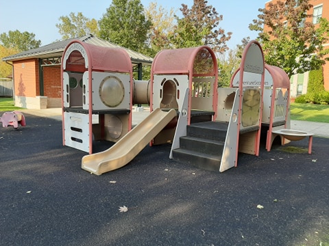 Playground with a slide and a building in the background
